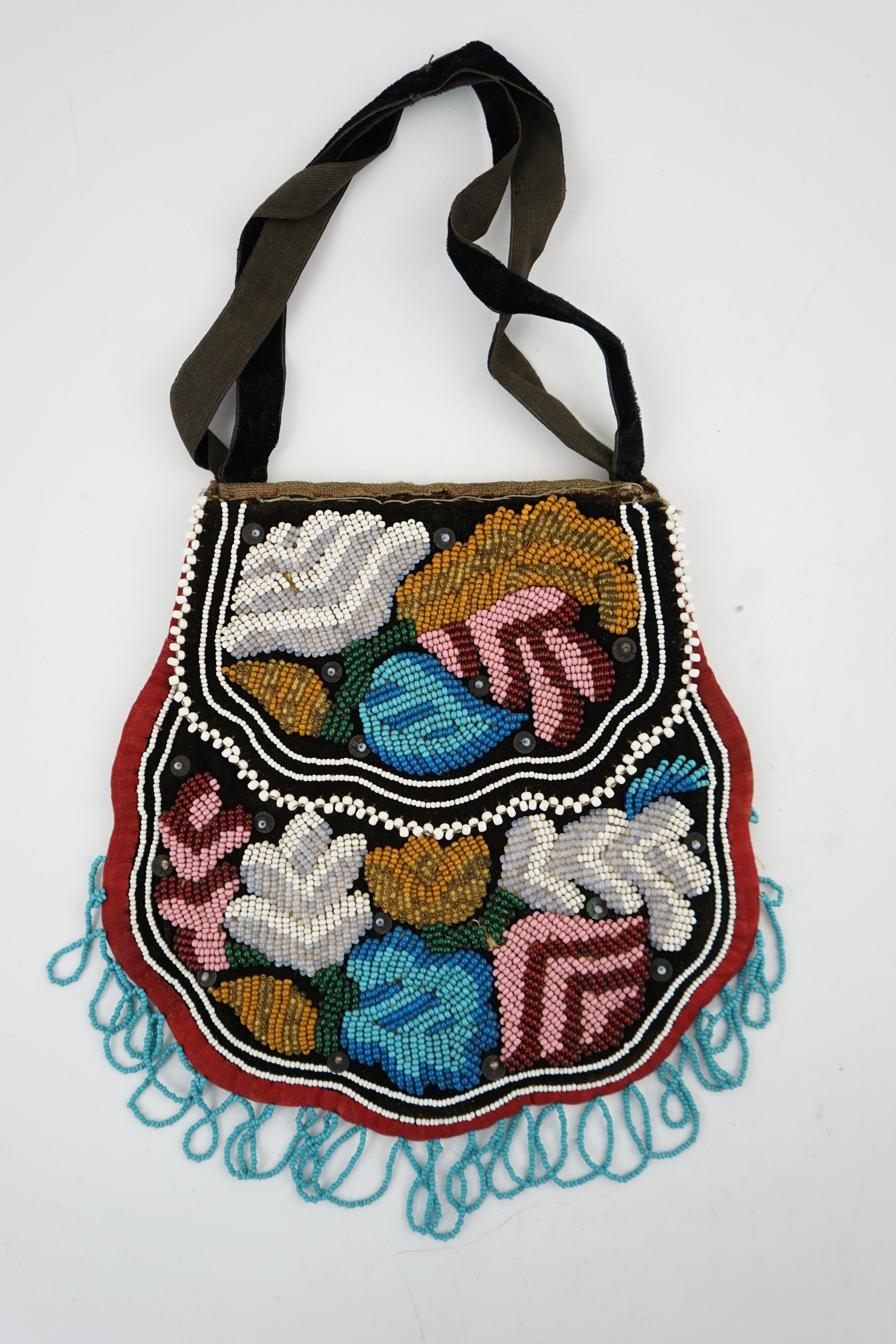 A 19th century Iroquois Native American beaded bag worked in a tightly grouped pattern of multi-coloured beads, with flaps either side and small white bead borders, fringed a similar turquoise beads. 16cm high. Condition